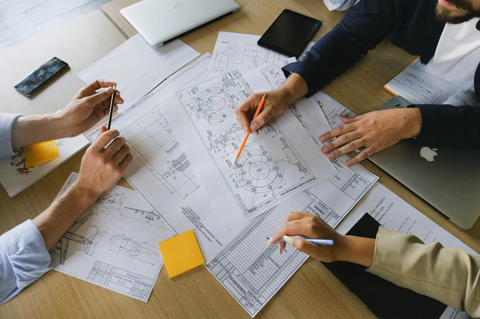 Tým analytiků diskutuje nad grafy na monitoru